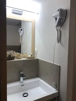 a bathroom sink with a hair dryer and a mirror at Residencecalou in Saint-Gervais-les-Bains
