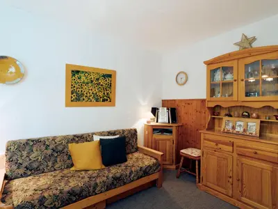 a bedroom with a bed and a wooden cabinet at Apartment Castel des Roches C4 by Interhome in Saint-Gervais-les-Bains