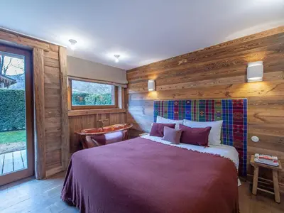 a bedroom with a bed and a bathroom with a tub at Duplex rénové au cœur de Megève, 3 chambres, cheminée, terrasse, équipements modernes. - FR-1-569-72 in Megève