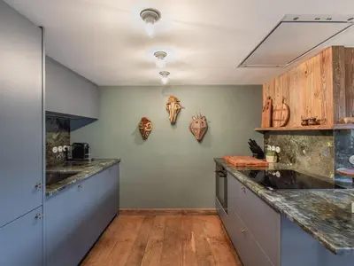 a large kitchen with wooden counter tops and wooden floors at Duplex rénové au cœur de Megève, 3 chambres, cheminée, terrasse, équipements modernes. - FR-1-569-72 in Megève