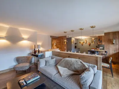 a living room with a couch and a kitchen at Duplex rénové au cœur de Megève, 3 chambres, cheminée, terrasse, équipements modernes. - FR-1-569-72 in Megève
