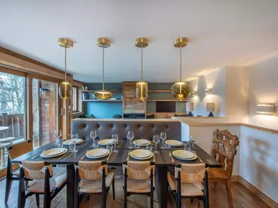 a dining room with a long table and chairs at Duplex rénové au cœur de Megève, 3 chambres, cheminée, terrasse, équipements modernes. - FR-1-569-72 in Megève