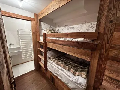 a large wooden bunk bed in a room at Duplex rénové au cœur de Megève, 3 chambres, cheminée, terrasse, équipements modernes. - FR-1-569-72 in Megève