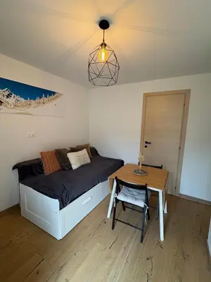 a small bedroom with a bed and a table at Charmant studio Saint Gervais 74 in Saint-Gervais-les-Bains