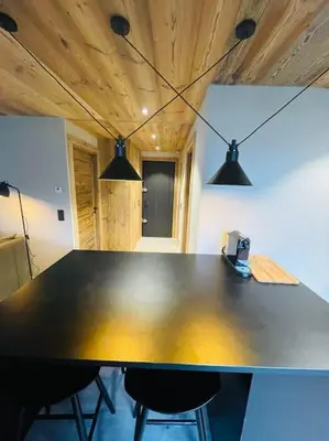 a black table with two chairs and two lights at Romy appartement centre village in Megève