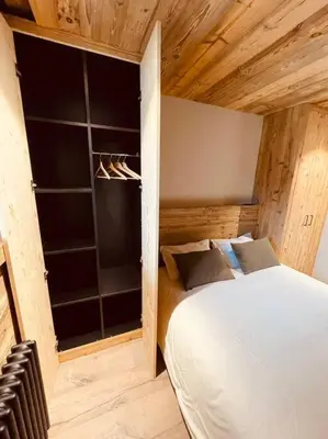 a bedroom with a white bed and a large window at Romy appartement centre village in Megève