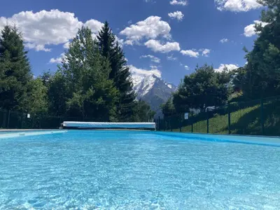a swimming pool with a mountain in the background at Le cocon du Bettex 1400 - Cozy Apt near Mont Blanc in Saint-Gervais-les-Bains