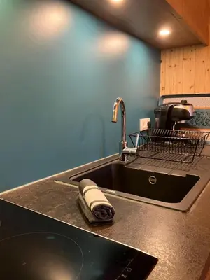 a kitchen counter with a sink with a towel at Le cocon du Bettex 1400 - Cozy Apt near Mont Blanc in Saint-Gervais-les-Bains