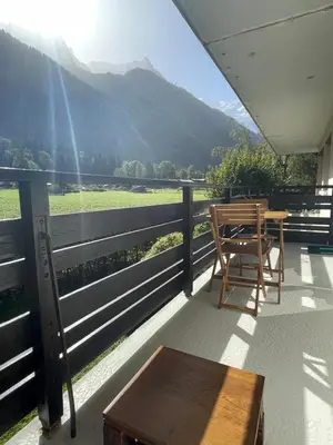 a table and chairs on a balcony with a view at Résidence Bois du Bouchet, appartement vue montagne, calme, parking gratuit, proche centre in Chamonix-Mont-Blanc