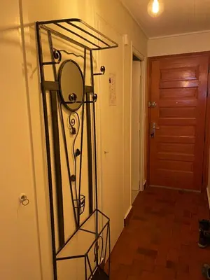 a mirror on a stand in a hallway at Résidence Bois du Bouchet, appartement vue montagne, calme, parking gratuit, proche centre in Chamonix-Mont-Blanc