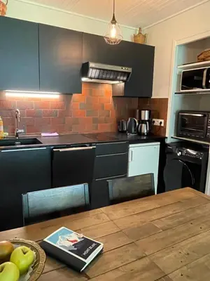 a kitchen with a wooden table with apples on the table at Résidence Bois du Bouchet, appartement vue montagne, calme, parking gratuit, proche centre in Chamonix-Mont-Blanc