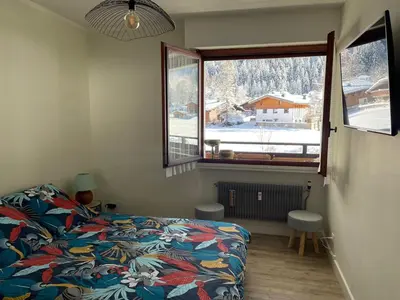 a bedroom with a bed and a window at Résidence Bois du Bouchet, appartement vue montagne, calme, parking gratuit, proche centre in Chamonix-Mont-Blanc