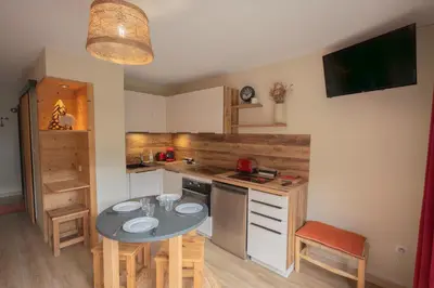 a small kitchen with a table and a counter top at Le Cristal du Mont-Blanc in Saint-Gervais-les-Bains