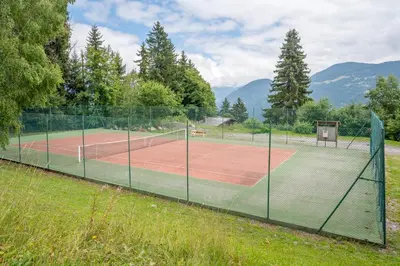 a tennis court with two tennis courts at Le Cristal du Mont-Blanc in Saint-Gervais-les-Bains