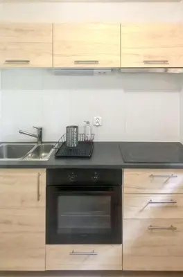 a kitchen with a sink and a black oven at Appartement cosy à Samoëns de 57 m² avec balcon. in Samoëns