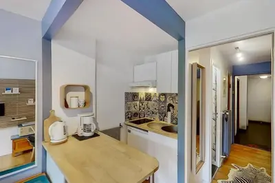 a kitchen with white cabinets and a wooden counter top at Studio moderne de 18m2 aux carroz d'arâches in Les Carroz d'Araches