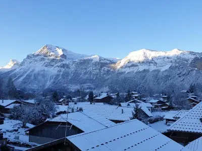 a village with snow covered mountains in the background at Studio moderne de 18m2 aux carroz d'arâches in Les Carroz d'Araches