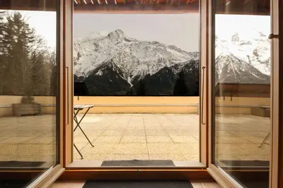 a large window with a view of a mountain at Betulle - 2bedroom - Patio facing Mont-Blanc range in Les Houches
