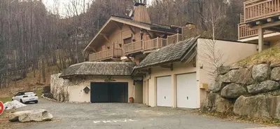 a large building with a garage and a balcony at Betulle - 2bedroom - Patio facing Mont-Blanc range in Les Houches