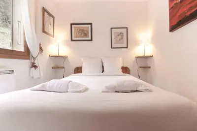 a bedroom with a white bed with two pillows at Betulle - 2bedroom - Patio facing Mont-Blanc range in Les Houches