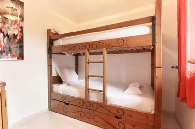 two bunk beds in a room with a ladder at Betulle - 2bedroom - Patio facing Mont-Blanc range in Les Houches