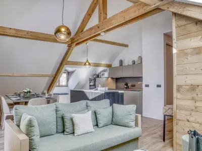 a living room with a blue couch and a kitchen at Appartement accueillant 6 pers, proche centre et télécabine, wifi inclus - FR-1-663-19 in Saint-Gervais-les-Bains