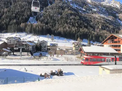 a red train on the tracks in a snow covered village at Chez Charles I Vallorcine Viachamonix in Vallorcine