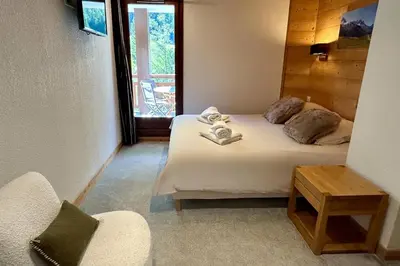 a bedroom with two beds and a chair and a window at Chez Charles I Vallorcine Viachamonix in Vallorcine