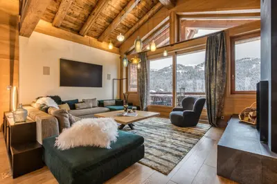 a living room with a couch and a tv at Rock and Stars Megève in Megève