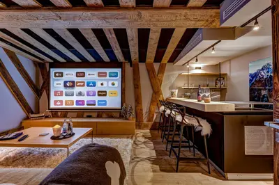 a kitchen with a bar with a tv on the wall at Chalet Red Fox in Chamonix-Mont-Blanc