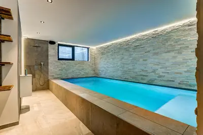 a large swimming pool in a room with a brick wall at Chalet Red Fox in Chamonix-Mont-Blanc