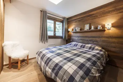 a bedroom with a bed and a chair in it at Flat Simba - Megève - Mont d'Arbois in Megève