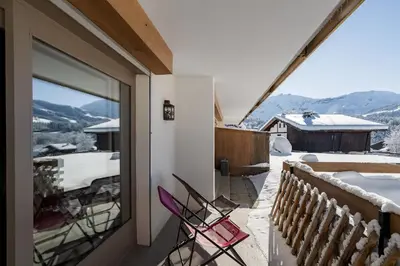 a pair of chairs sitting on the balcony of a house at Flat Simba - Megève - Mont d'Arbois in Megève