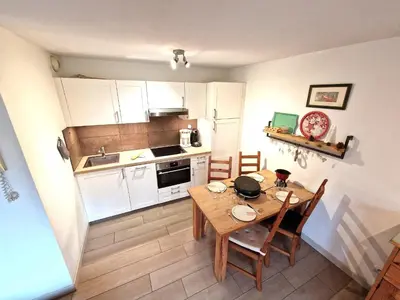 a small kitchen with a wooden table and chairs at L'Appart de Chacha 2ch, 4pers Centre de Chamonix in Chamonix-Mont-Blanc