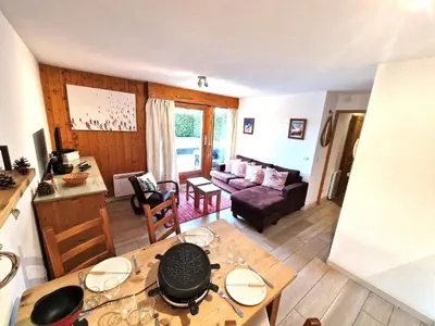 a living room with a table and a couch at L'Appart de Chacha 2ch, 4pers Centre de Chamonix in Chamonix-Mont-Blanc