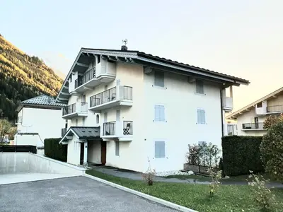 a white building with balconies and a parking lot at L'Appart de Chacha 2ch, 4pers Centre de Chamonix in Chamonix-Mont-Blanc
