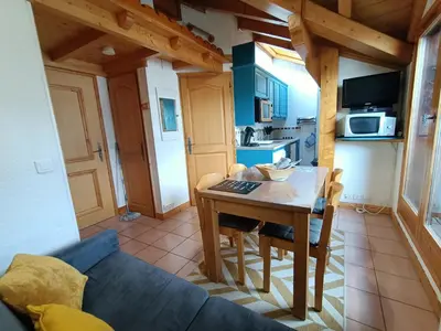 a living room with a table and a blue couch at Cocon familial proche télécabine in Saint-Gervais-les-Bains