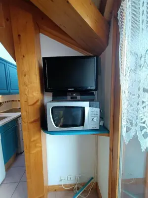a microwave sitting on a shelf in a kitchen at Cocon familial proche télécabine in Saint-Gervais-les-Bains