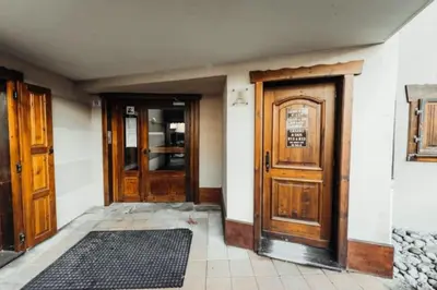 an empty room with two doors and a rug at Cocon familial proche télécabine in Saint-Gervais-les-Bains