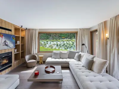 a living room with a white couch and a large window at Appartement Neuf, Jardin Privé, 3 Chambres, Megève Mont d'Arbois - FR-1-569-73 in Megève