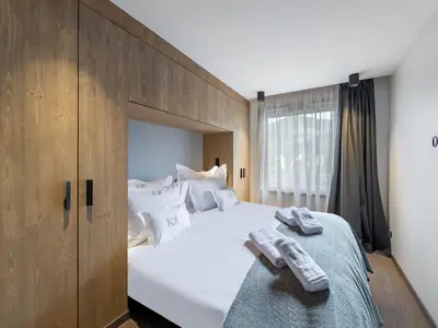 a bedroom with a large white bed with towels on it at Appartement Neuf, Jardin Privé, 3 Chambres, Megève Mont d'Arbois - FR-1-569-73 in Megève