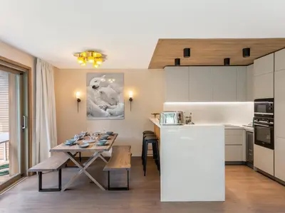a kitchen and living room with a table and chairs at Appartement Neuf, Jardin Privé, 3 Chambres, Megève Mont d'Arbois - FR-1-569-73 in Megève