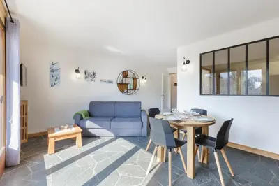 a living room with a blue couch and a table at Appartement Flégère et Golf - Happy Rentals in Chamonix-Mont-Blanc