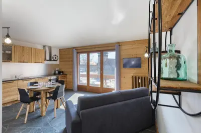 a kitchen and living room with a table and chairs at Appartement Flégère et Golf - Happy Rentals in Chamonix-Mont-Blanc