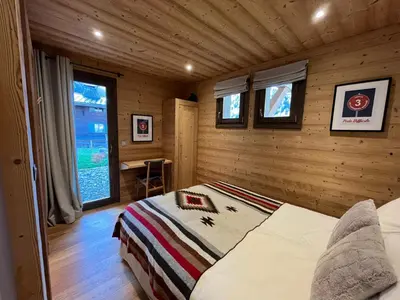 a bedroom with a bed in a log cabin at Chalet les 3 cerfs in Les Contamines-Montjoie