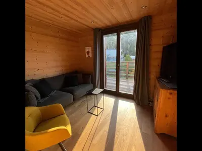 a living room with a couch and a chair and a television at Chalet les 3 cerfs in Les Contamines-Montjoie
