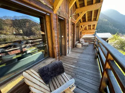 a porch of a log cabin with a bench on it at Chalet les 3 cerfs in Les Contamines-Montjoie
