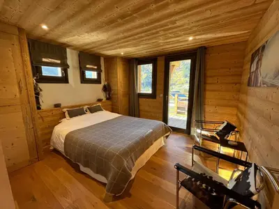 a bedroom with a bed in a wooden cabin at Chalet les 3 cerfs in Les Contamines-Montjoie