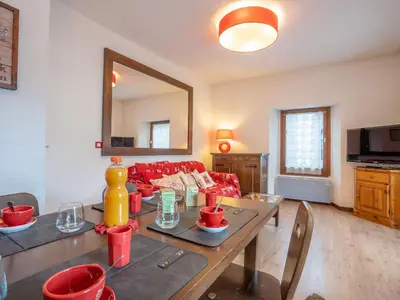 a living room with a red couch and a table at Apartment Le Pavillon-3 by Interhome in Chamonix-Mont-Blanc
