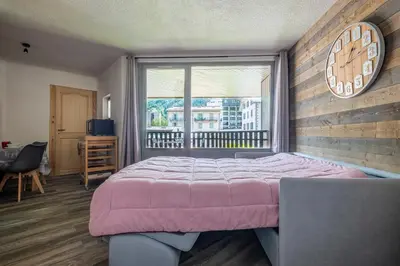 a bedroom with a pink bed and a window at Superbe appartement avec parking gratuit en centre ville et aux pieds des pistes in Chamonix-Mont-Blanc